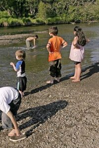 children playing outside at a creek 