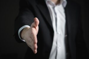 Man reaching out to shake hands. This image is describing the blog site affiliate disclosure. 