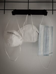 3 different type of sterile masks on hanger attached to a white wall for protection against COVID-19