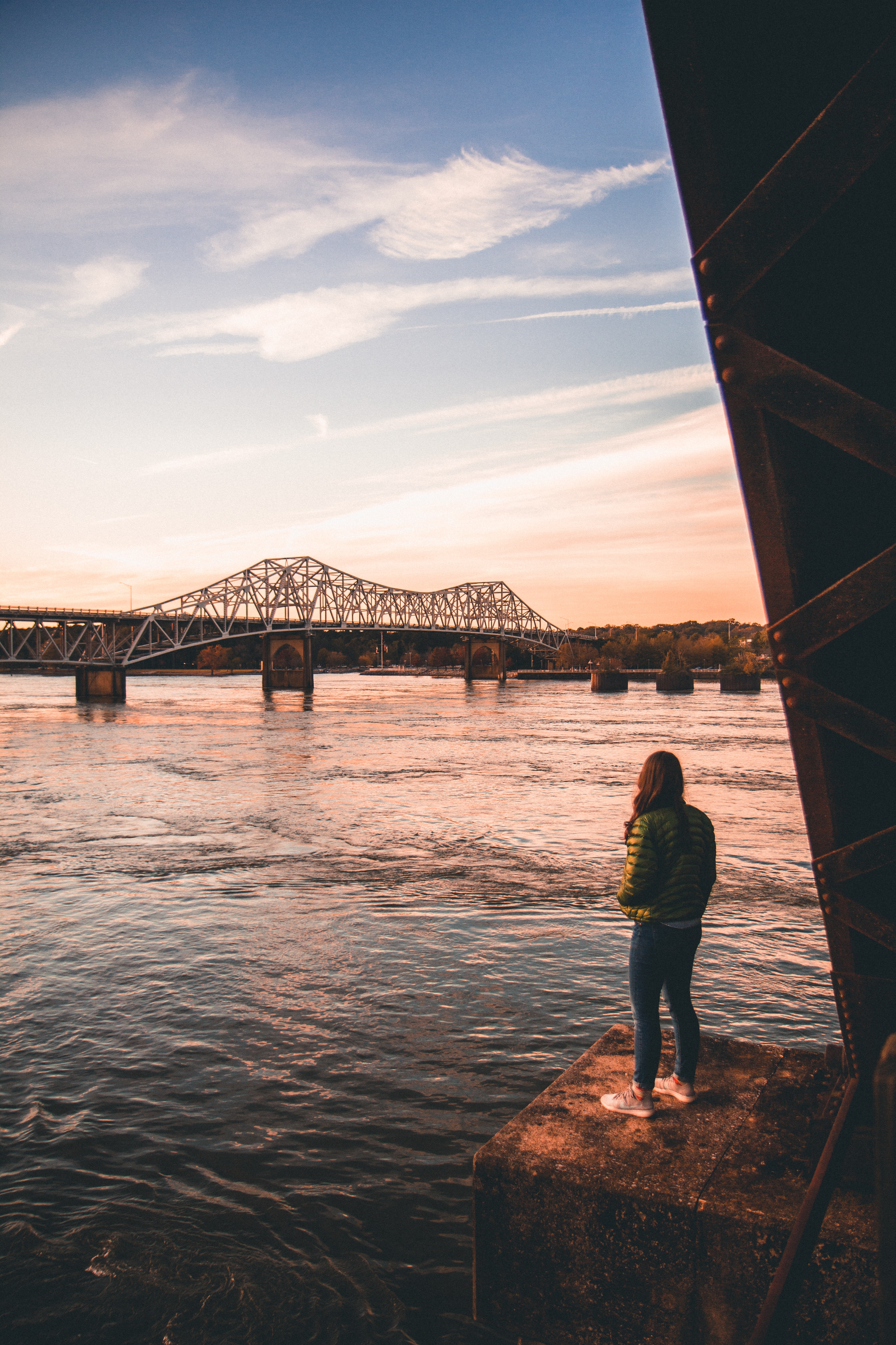 Student standing by a river looking at a railroad bridge near Muscle Shoals, Alabama